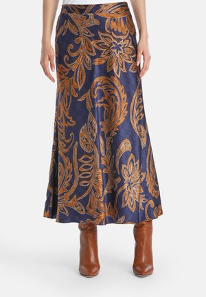 Lange marineblauwe rok met oranje bloemenpatronen, soepele textuur, uitlopende stijl, halverwege de kuit in lengte, gedragen met bruine hoge hakken.