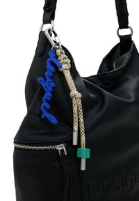 Bolso de mano de piel negra con superficie texturizada, cremallera plateada y un llavero con logotipo azul adjunto con un detalle de cuerda trenzada.