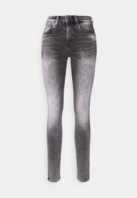 Jeans ajustados de talle alto negros con un lavado desgastado, que cuentan con cinco bolsillos, una cremallera y una textura de denim lisa y suave.