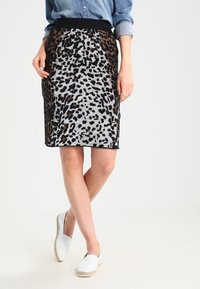 Knee-length leopardmönstrad kjol med svart elastisk midja. Har ett texturerat stickat tyg i grå, brun och svarta nyanser.