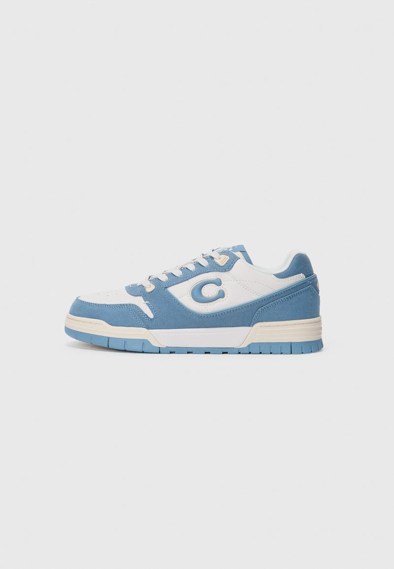 Låga sneakers med en ovandel i vit läder, blå mockadetaljer, beige snören och en strukturerad gummisula med ett blått mönster.