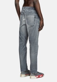 Jean en denim gris délavé, avec une coupe décontractée, une taille élastique et des poches arrière avec des coutures renforcées. Tissu durable.