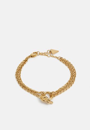 Gouden multi-chain armband met een knoopsluiting. Het ontwerp bevat getextureerde schakels en een kleine driehoekige tag met een logo.
