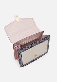 Strukturalna torebka w czarno-fioletowy wzór węża, z gładkim kremowym przednim panelem, złotymi okuciami oraz różowym wnętrzem wyłożonym podszewką z kieszenią na zamek.