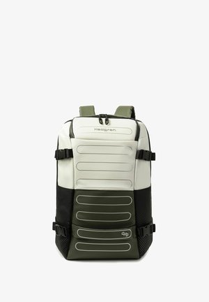 Rucksack mit weißen, grünen und schwarzen Paneelen, mehreren verstellbaren seitlichen Gurten und zwei oberen Reißverschluss-Zippern auf einfarbigem Hintergrund.