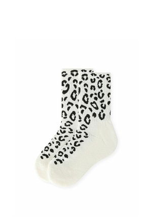 Paire de chaussettes montantes blanches avec un motif léopard noir sur tout le tissu, présentées côte à côte sur un fond blanc.