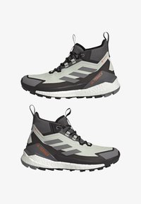 Wysokie buty do biegania w terenie w jasnoszarym i czarnym kolorze. Charakteryzują się siateczkową cholewką, gumową podeszwą, odblaskowymi akcentami oraz amortyzowaną podeszwą.
