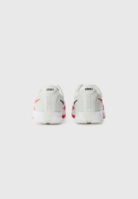 Gray athletic shoes with red and black accents, textured material, and a padded heel. Features a 001 label and patterned soles.
