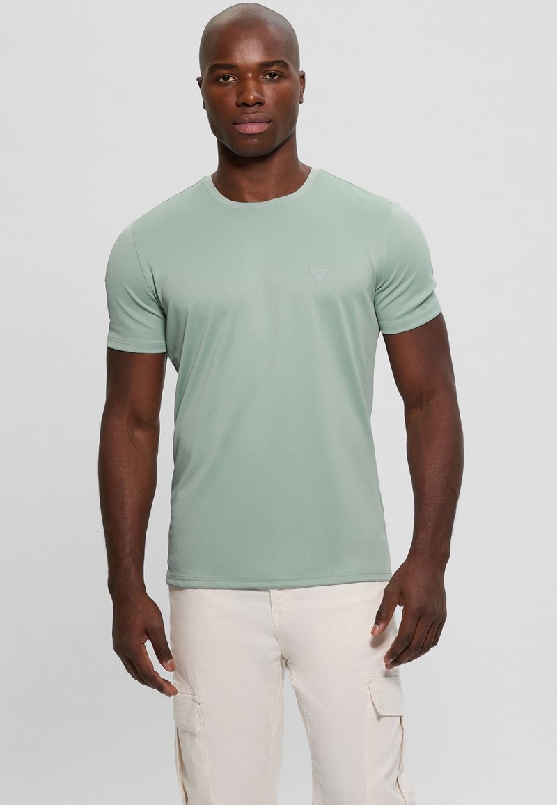 Camiseta de manga corta verde claro hecha de tela suave, con cuello redondo y un logotipo sutil en el pecho.