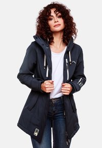 Navy long jacket with a fitted design, hood, drawstrings, dual zippers, and multiple pockets. Made from soft, textured fabric.