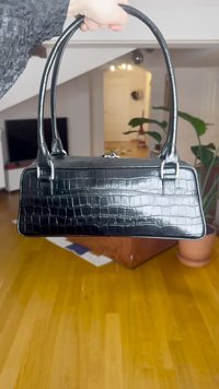 Svart kunstlærveske med krokodilletekstur, rektangulær form, doble håndtak og en glatt, blank finish.