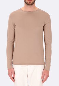 Camicia a maniche lunghe di colore marrone chiaro, realizzata in un tessuto morbido. Presenta un collo rotondo e una vestibilità slim, con dettagli di cucitura sottili lungo le giunture.