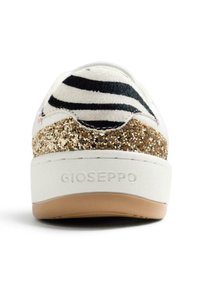 Zapatilla deportiva con cuerpo blanco, tejido a rayas negras y blancas en el talón, y un detalle dorado brillante. Nombre de la marca "GIOSEPPO" grabado en el lateral.