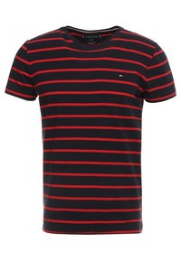 Camiseta negra de manga corta con rayas rojas horizontales. Cuenta con un cuello redondo y un pequeño logo en el pecho. Fabricada en suave material de algodón.