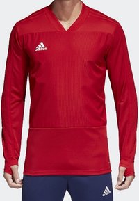 Maillot de football rouge à manches longues avec un col en V ; présente des rayures verticales et le logo Adidas en blanc. Fabriqué en matériau léger et respirant.