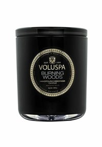 Svart glasljusburk med guld detaljer, märkt "Voluspa Burning Woods." Rymmer 9,5 oz handgjord cocowax och har en slät yta.