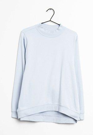 Hellblaues langärmliges Sweatshirt mit einem gerippten hohen Kragen und Saum, der an einem schwarzen Kleiderbügel vor einem weißen Hintergrund hängt.