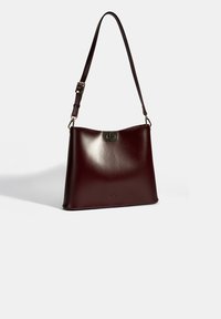 burgundy lederen handtas met een gladde textuur, schouderriem en een goudkleurige hardware sluiting. Heeft een minimalistisch ontwerp en subtiele branding.