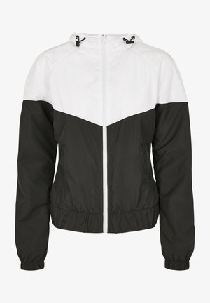 Čierno-biely vetrovka s predným zipsom, elastickými manžetami a kapucňou; má chevronový dizajn a zhromaždený pás.