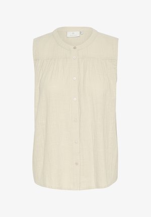 Gaiši bež bezpiedurkņu blūze, izgatavota no teksturētas auduma; ar apaļu izgriezumu un sešām pogām pa vidu.