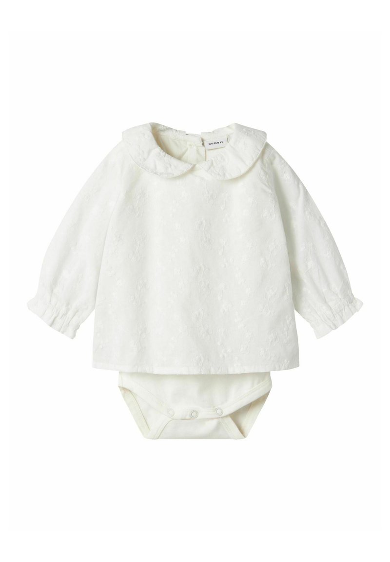 Maglietta bianca a maniche lunghe con colletto arrotondato e motivo floreale a rilievo, abbinata a un body coordinato con chiusure a pressione.