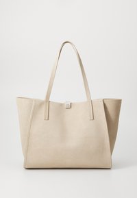 Beige ruskinds tote taske med doble flade håndtag, struktureret form og minimalistisk design. Bemærkelsesværdig syning og en lille metallisk logoaccent.