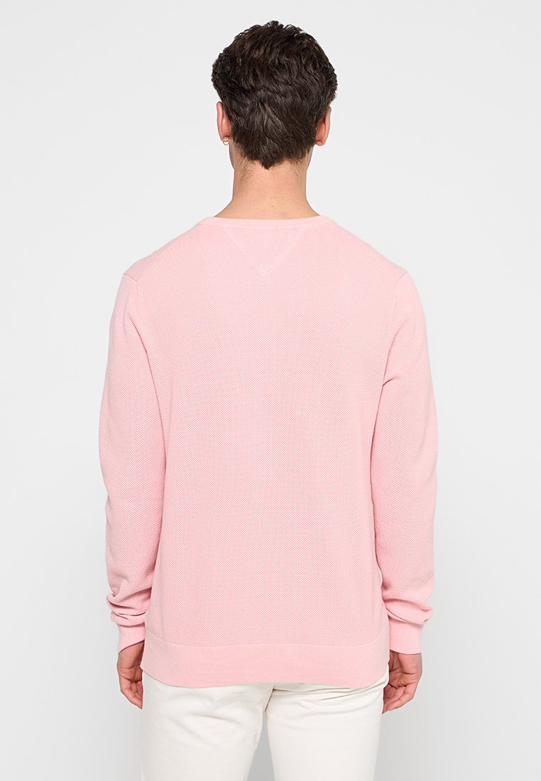 Hellrosa, strukturiertes Sweatshirt mit langen Ärmeln und einem Rundhalsausschnitt, das an Saum und Bündchen gerippt ist für eine enganliegende Passform.