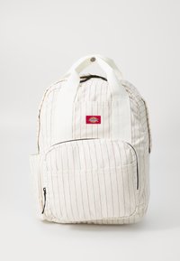 Rucsac din țesătură albă cu dungi verticale roșii, mânere de transport sus, buzunar frontal cu fermoar și o mică etichetă cu logo. Material din bumbac texturat.