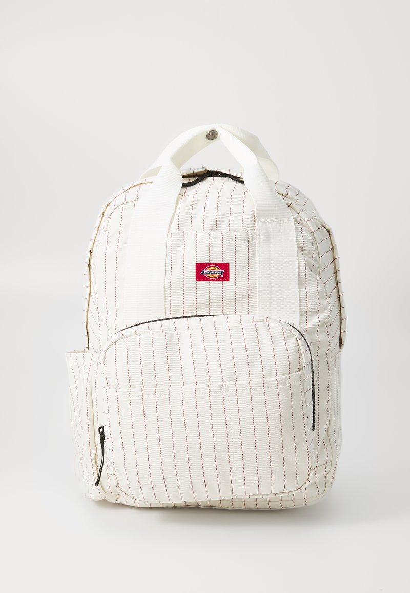 Rucsac din țesătură albă cu dungi verticale roșii, mânere de transport sus, buzunar frontal cu fermoar și o mică etichetă cu logo. Material din bumbac texturat.