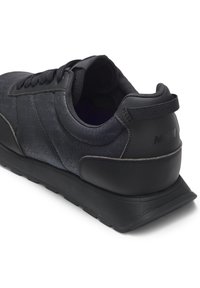 Schwarzer Sportschuh mit strukturiertem Obermaterial, Schnürsystem, gepolstertem Kragen und kontrastierendem, glattem Fersenbereich. Gummi-Außensohle für Traktion.