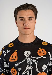 Czarny sweter dzianinowy z motywami Halloween: pomarańczowe dynie, białe szkielety i duchy, z prążkowanym dekoltem i miękką teksturą.