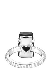 Silberner Ring mit einem schwarz-weißen Bärenmotiv oben und einem herzförmigen Ausschnitt. Der Ringkopf ist mit "THOMAS SABO x HARIBO" graviert.