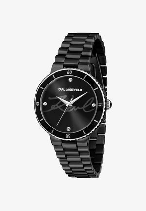 Orologio in metallo nero con quadrante rotondo, dettagli argento, firma "Karl" sul quadrante e indicatori in cristallo. Cinturino a maglie con finitura lucida.