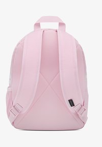 Ροζ σακίδιο με επενδεδυμένους ιμάντες από πλέγμα, χειρολαβή στην κορυφή και υφή στην επιφάνεια. Διαθέτει ετικέτα στο πλάι και καθαρό, λιτό σχέδιο.