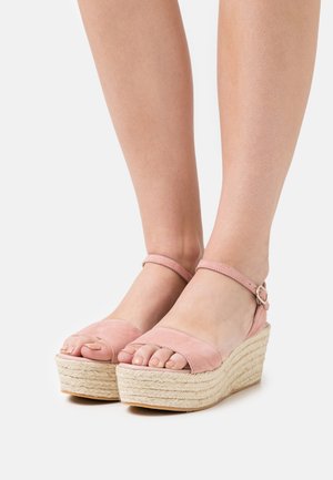 Sandali con zeppa in suede rosa, dotati di cinturino alla caviglia e una piattaforma in giute intrecciato. Design open-toe che mette in risalto le dita dei piedi. Texture liscia.