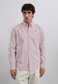 Langärmliges Hemd mit Knöpfen in rot-weiß gestreift. Mit spitzem Kragen und kleinem, aufgesticktem Logo auf der Brust. Aus Baumwollmaterial.