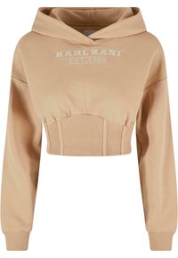 Felpa beige tagliata, realizzata in tessuto morbido con accenti a coste. Presenta un cappuccio e un ricamo frontale con la scritta "KARL KANI EST. 1989."