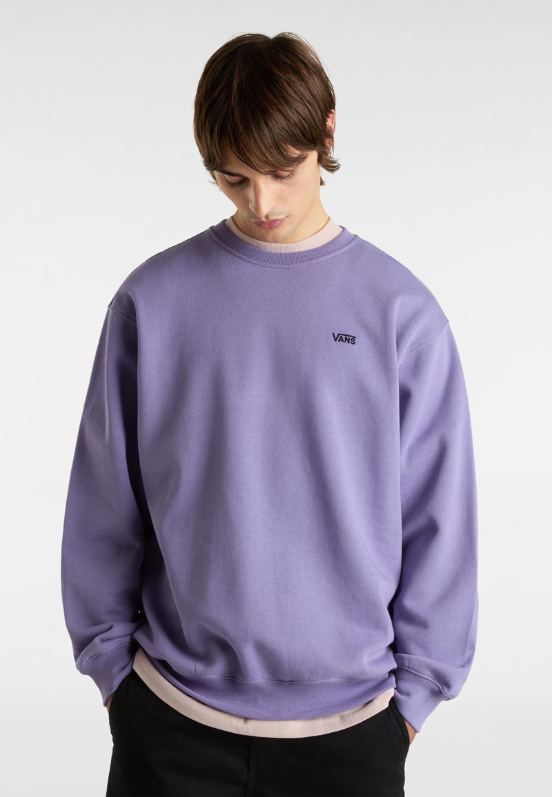 Sudadera púrpura confeccionada en una mezcla de algodón, con un cuello redondo, puños acanalados y un pequeño logo negro de Vans en el pecho.