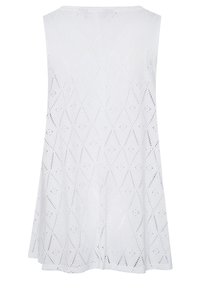 Vit ärmlös klänning med diamantsformad ögla och utsvängd nederkant, visad bakifrån mot en neutral bakgrund.