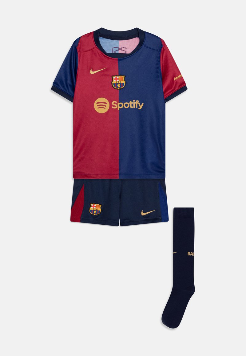 Maglia del Barcellona caratterizzata da una maglietta rossa e blu navy con dettagli dorati, pantaloni abbinati e calze blu navy con "BARÇA" stampato in oro.
