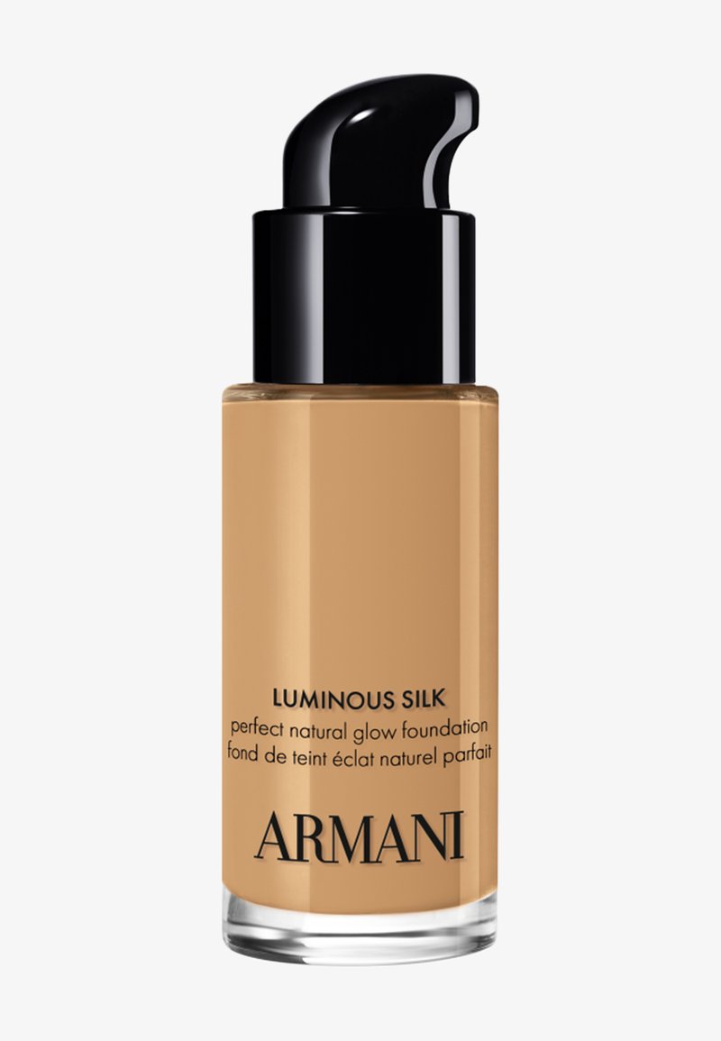 Bottiglia di fondotinta Armani Luminous Silk con erogatore a pompa nero e liquido beige visibile attraverso un contenitore in vetro trasparente.