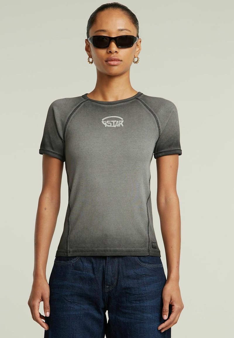 T-shirt atletica grigia con maniche corte, texture a coste e cuciture a contrasto. Presenta il logo sul petto e un design aderente.