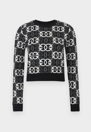 Sweater cortado em preto e branco com padrões geométricos intrincados, mangas longas e um decote e punhos canelados em preto sólido.