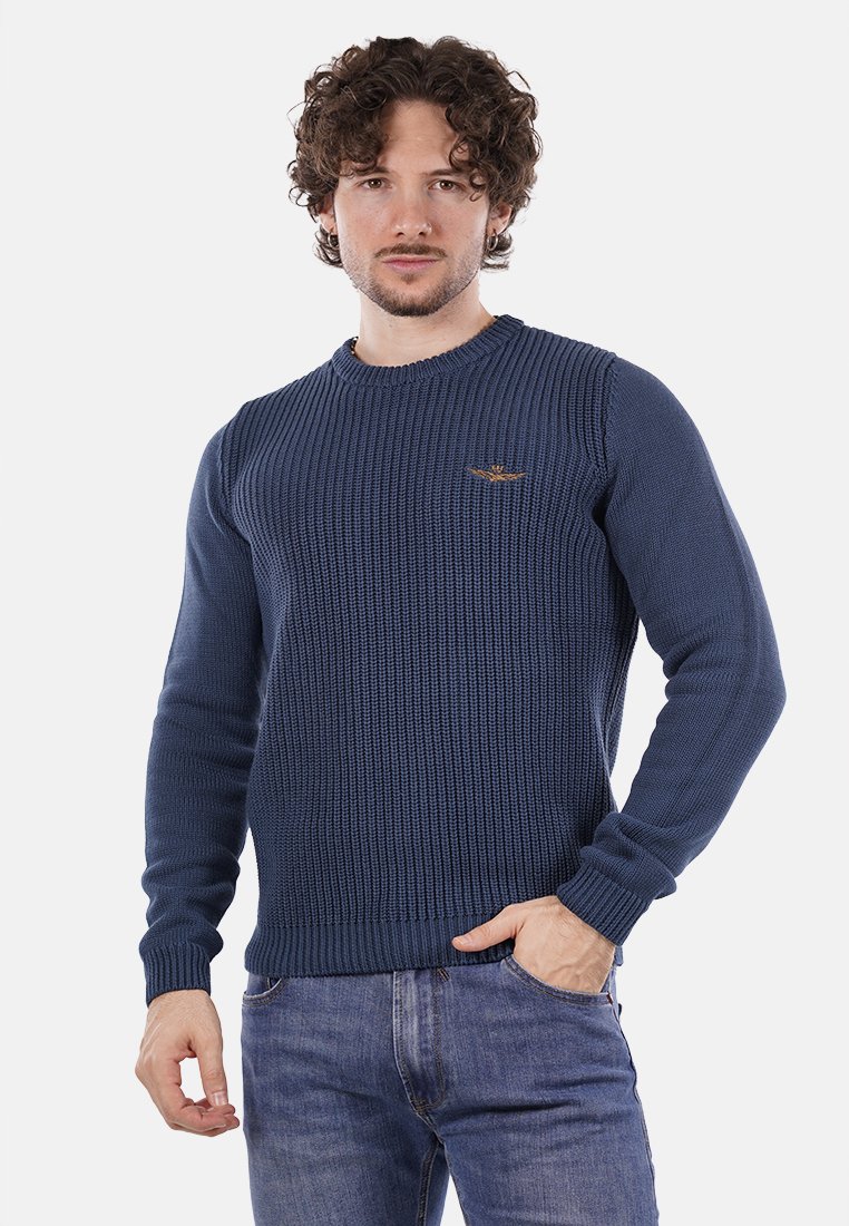 Maglione lavorato a maglia di colore blu navy con texture a costine e scollatura rotonda. Presenta maniche lunghe e un piccolo logo decorativo sul petto.