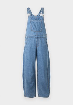 Μπλε τζιν φορμάκι με ρυθμιζόμενους ιμάντες ώμων, μπροστινή τσέπη στο στήθος, κουμπιά στο πλάι και παντελόνια με φαρδιά πόδια.