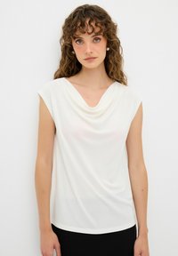 Weißes ärmelloses Top mit einem drapierten Ausschnitt, aus weichem Stoff gefertigt. Glatte Textur, leicht lockere Passform, ideal zum Schichten oder für den Alltag.