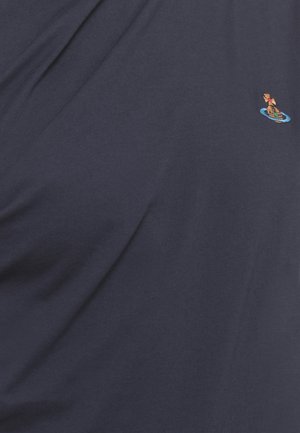 Tessuto blu scuro con un piccolo emblema multicolore ricamato vicino all'angolo in alto a destra.
