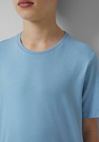 Lichtblauw t-shirt met korte mouwen, gemaakt van zachte stof, met een ronde halslijn en een gladde, gelijkmatige textuur zonder zichtbare patronen.