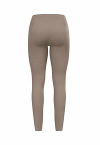 Beige Leggings aus glattem Stoff, mit hohem Taillenbund, figurnahem Design und nahtloser Verarbeitung ohne sichtbare Beschläge.