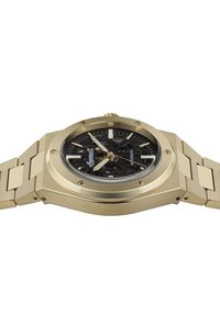 Gouden automatische horloge met een zwart skelet-dial, hoekige kastvorm en een schakelarmband ontwerp. Bevat gouden accenten en een transparante kast achterkant.